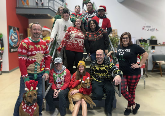 STKR Concepts crew posing for a holiday picture on the stairs in 2024