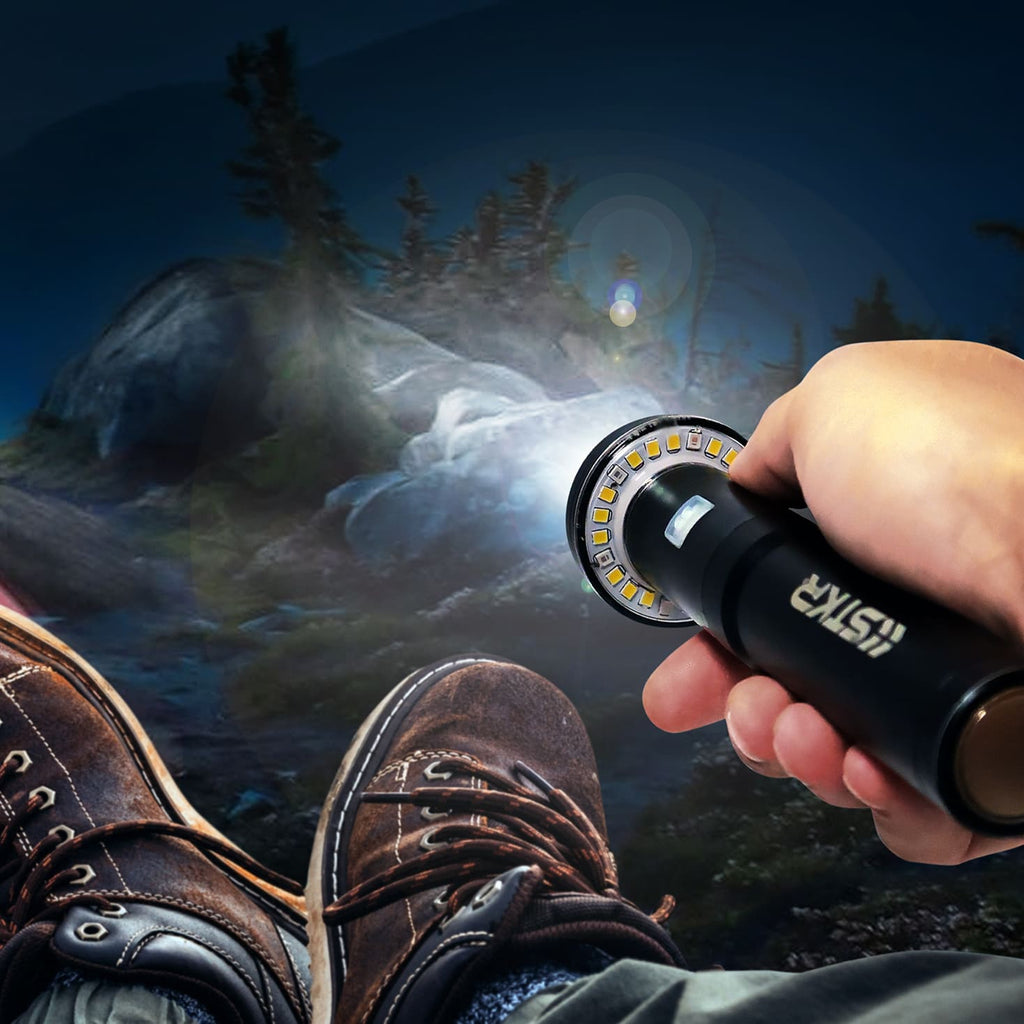 Hand holding a flashlight with a mountainous landscape in the background